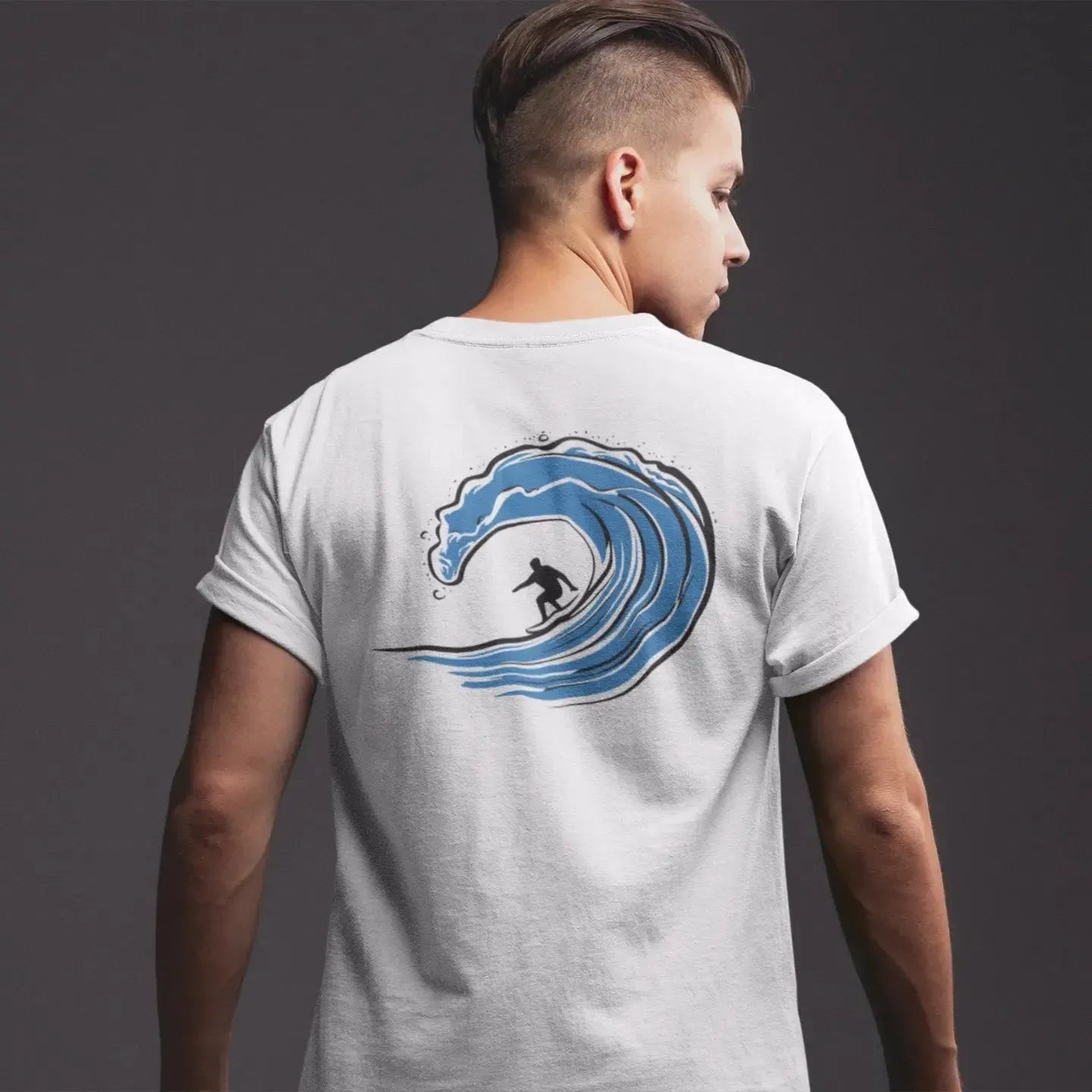 Person wearing a white t-shirt with a blue wave design on the back against a dark background