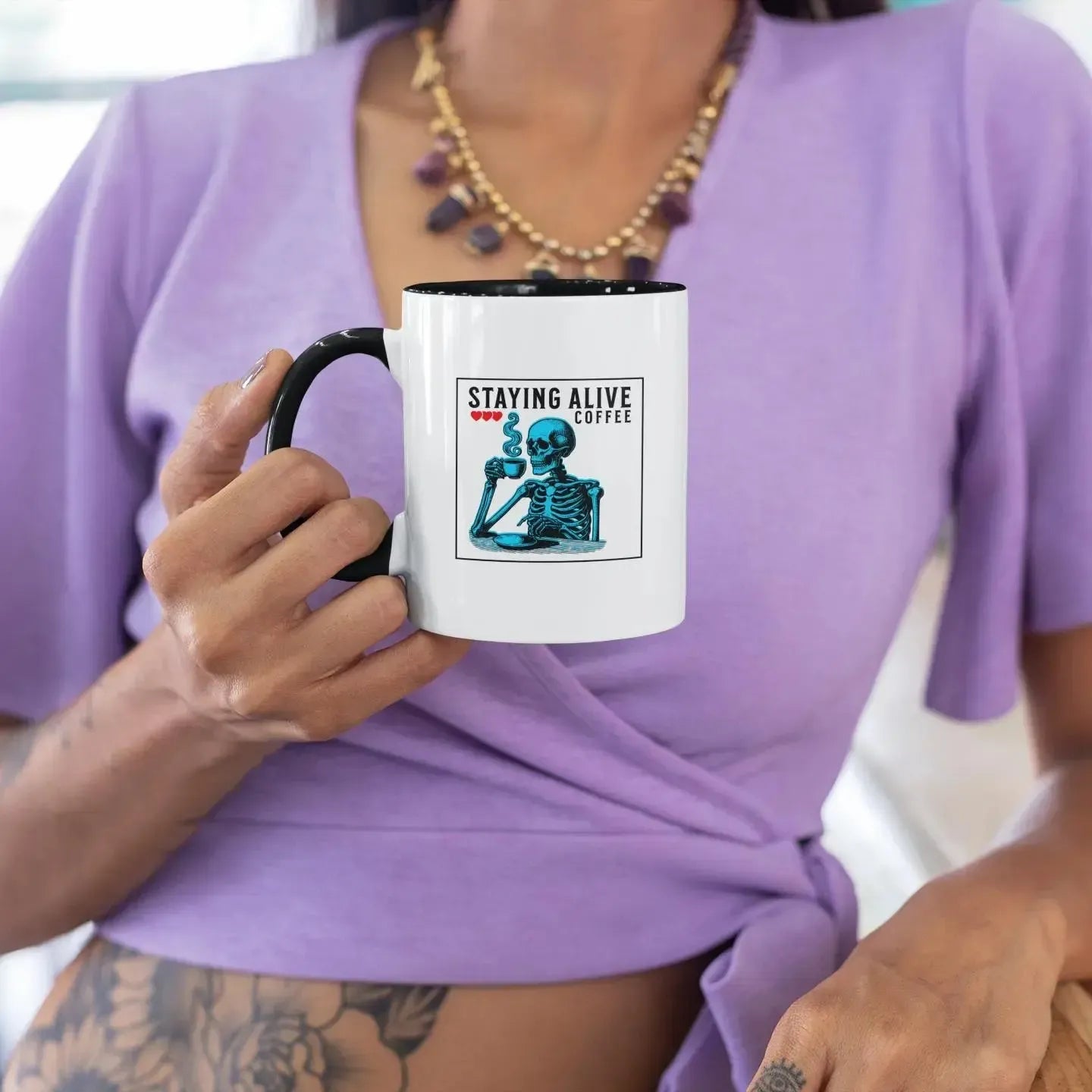 woman-holding-sarcastic-staying-alive-blue-skeleton-mug